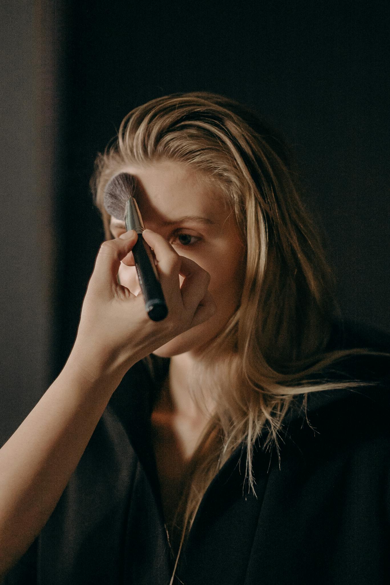A makeup artist applies cosmetics to a model in a professional beauty studio.