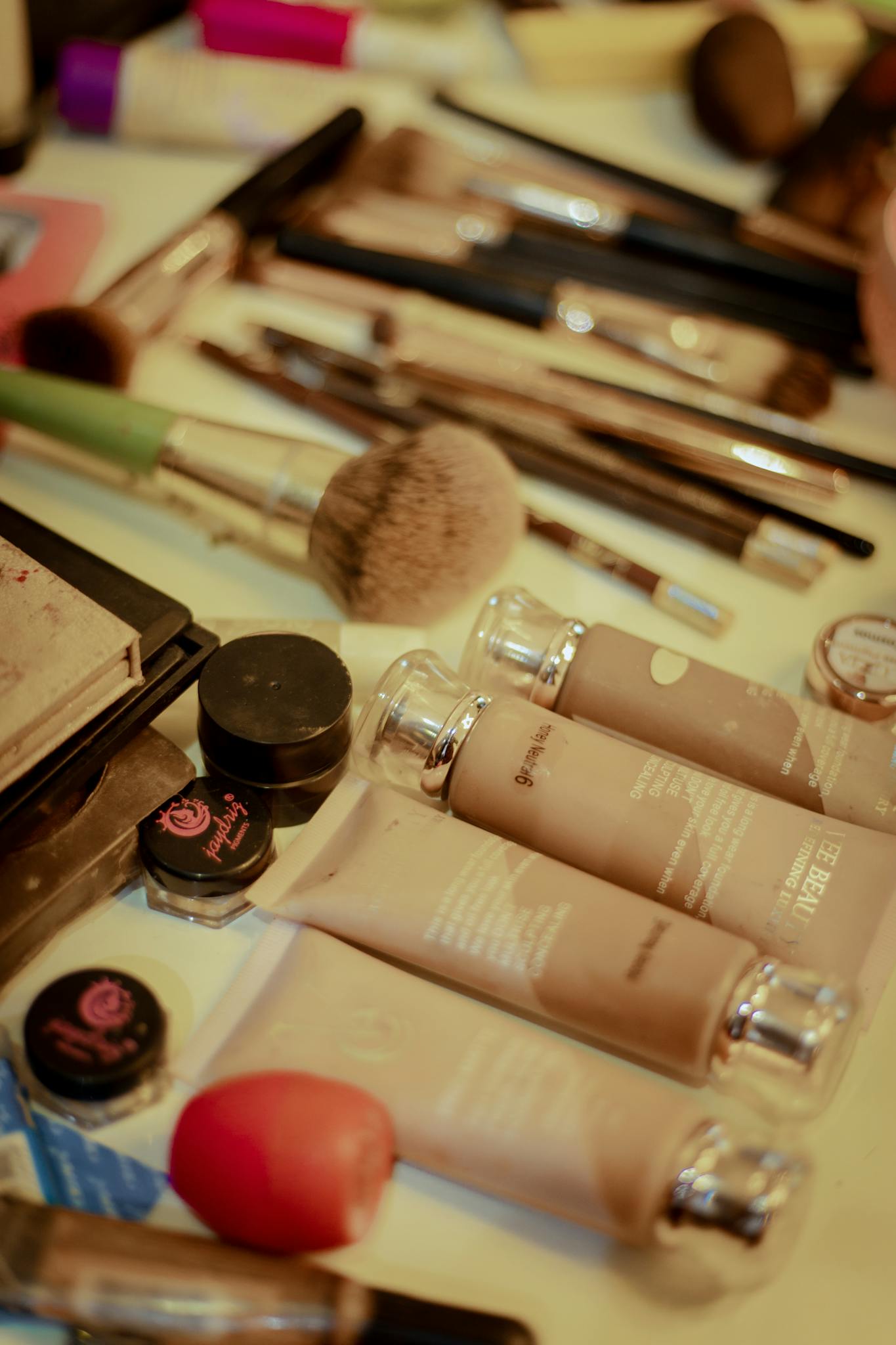 Close-up of various cosmetic items and brushes arrayed on a table.